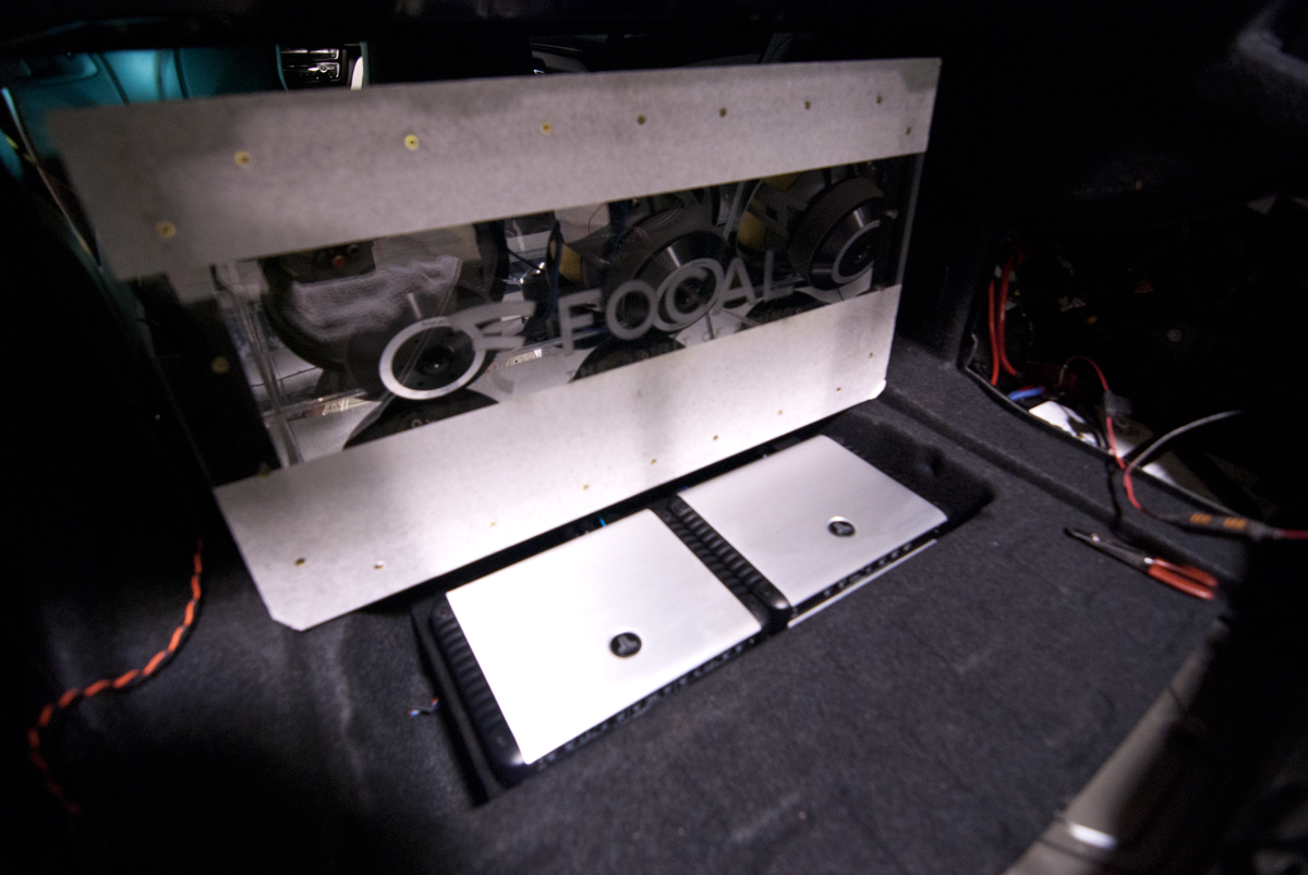 JL Audio HD amplifiers hidden in the floor storage compartment. Helix DSP Pro used for the sound calibration.